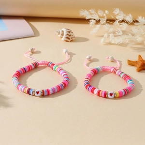 Détail du bracelet en perles d'argile colorées avec perle cœur et cordon ajustable