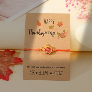 Nahaufnahme von gewebtem Ahornblatt-Armband auf Happy Thanksgiving Grußkarte