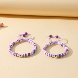 Détail de deux bracelets faits main avec perles heishi colorées et cordon tressé réglable