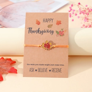 Detail eines handgefertigten Thanksgiving-Armbands mit Ahornblatt auf einer Karte