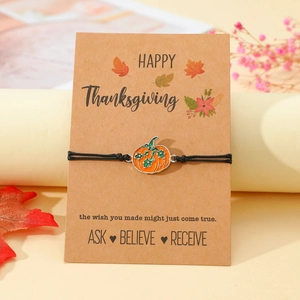 Detail des Thanksgiving-Armbands mit Kürbis-Anhänger auf einer Grußkarte aus Kraftpapier