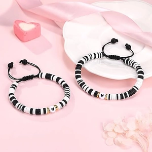 Détail de bracelets faits main avec perles en cœur, cordons noirs et perles Heishi argile