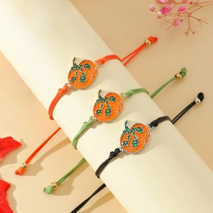 Detail der handgefertigten geflochtenen Kürbis-Armbänder in Orange Grün und Schwarz