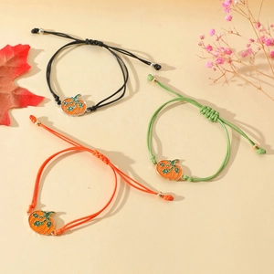 Detailansicht von drei verstellbaren geflochtenen Armbändern mit Kürbis-Anhängern