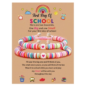 Gros plan de deux bracelets en perles Heishi à cœur sur une carte de message scolaire
