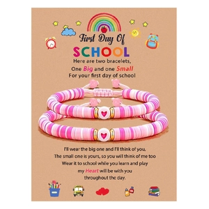 Gros plan de bracelets de perles faits main sur une carte cadeau thème école
