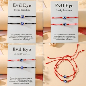 Détail de bracelets Evil Eye tressés faits main en rouge et noir avec cordon ajustable