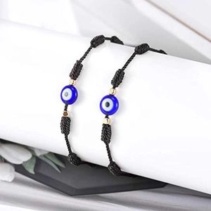 Détail de bracelets faits main avec œil bleu maléfique sur présentoirs blancs