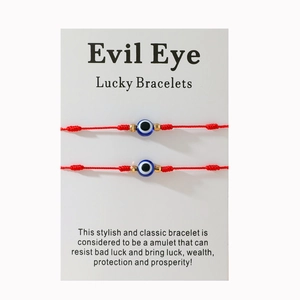 Détail de bracelets rouges mauvais œil à sept nœuds avec perles dorées