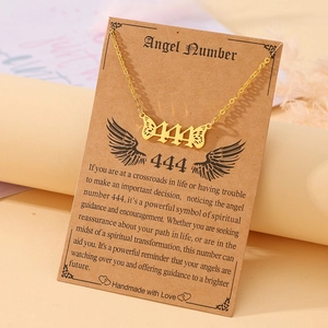 Detailed view of gold angel number 444 necklace with wings on spiritual message card
