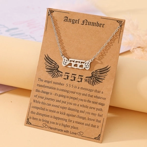 Detailed view of the 555 angel number necklace with wings on a vintage display card