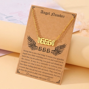 Detail of 666 angel number necklace in gold with wings on a meaning display card
