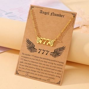 Detail of gold angel number 777 necklace with butterfly wings on gift description card