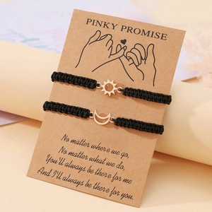 Dettaglio dei bracciali intrecciati sole e luna su biglietto vintage Pinky Promise