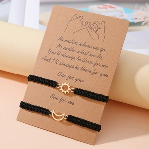 Dettaglio di braccialetti intrecciati a mano con sole e luna su carta kraft marrone