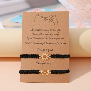 Dettaglio dei braccialetti intrecciati sole e luna su un biglietto regalo