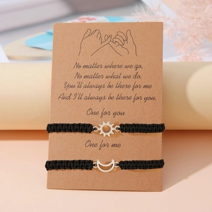 Dettaglio dei bracciali per coppie sole e luna su una cartolina regalo in kraft