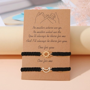 Dettaglio dei braccialetti dell'amicizia sole e luna tessuti a mano su biglietto