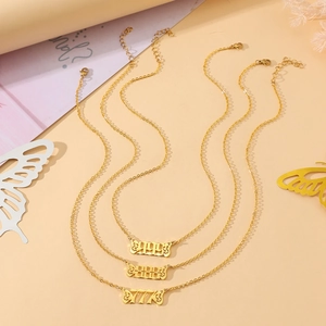 Detailed view of three gold angel number necklaces with butterfly frames 999 888 777