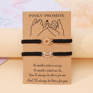Dettaglio dei bracciali regolabili sole e luna su biglietto regalo Pinky Promise