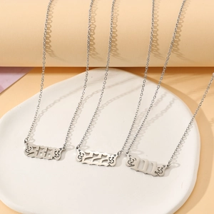 Detailed view of silver stainless steel necklaces with butterfly wing and gothic numbers