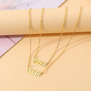 Detailed macro view of gold plated necklaces featuring 555 and 666 angel wing pendants