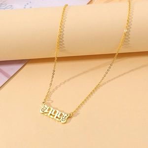 Macro shot of 1991 gold number pendant with angel wings on a minimalist background