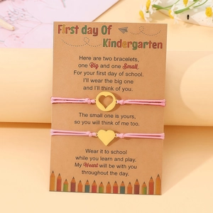 Detailansicht der rosa geflochtenen Armbänder mit Herzanhängern auf Kindergarten-Karte