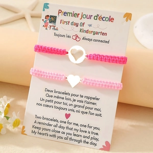 Detail von rosa geflochtenen Herzarmbändern mit Geschenkkarte für den ersten Schultag