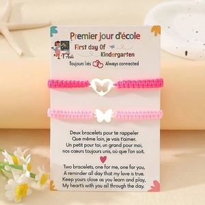 Nahaufnahme der rosa Schmetterlings-Armbänder auf Geschenkkarte zum Schulanfang