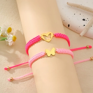 Detailansicht gewebter rosa Kordelarmbänder mit goldenen Herz- und Schmetterlingsanhängern