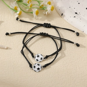 Détail de deux bracelets de football ajustables avec cordons noirs tressés et décor floral