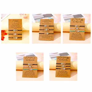 Detail of woven promise bracelets with moon and sun charms on kraft paper greeting cards