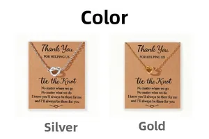 Collares de nudo de corazón plata y oro sobre tarjetas de kraft con mensajes tiernos