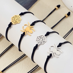 Detailed macro of handmade woven spider and cobweb charms in gold and silver finish