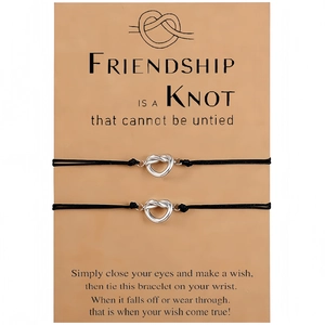 Set of two black woven heart knot friendship bracelets on a gift card with text