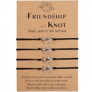 Set of four adjustable black woven friendship bracelets with silver heart knot charms