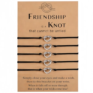 Five-piece set of black braided friendship bracelets with silver metal knot charms on card