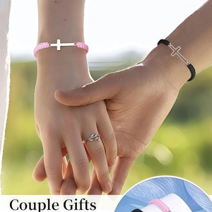 Detailed view of woven couple bracelets with cross charms and a silver leaf ring