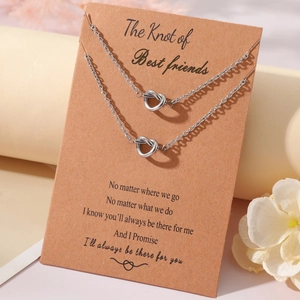 Detail of two stainless steel heart knot necklaces on a friendship display card