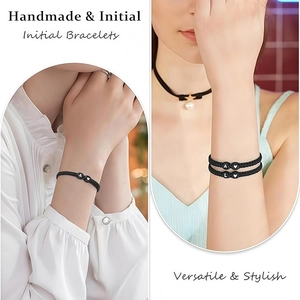 Detail van handgemaakte zwarte gevlochten letterarmband en ster-choker bij een model