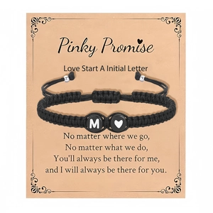 Detail van geweven armband met letter M en hartje op een Pinky Promise geschenkkaartje