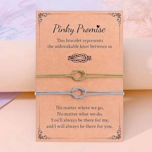 Λεπτομέρεια από βραχιόλια με κόμπο Pinky Promise σε χρυσό και ασήμι σε διακοσμητική κάρτα