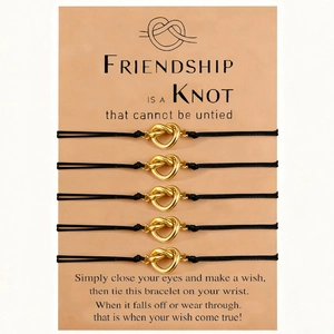 Close-up of 5-piece friendship bracelet set with golden heart knots on kraft cards