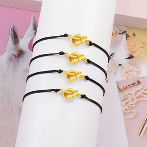 Detail of four black braided rope bracelets with a golden heart knot on a display stand