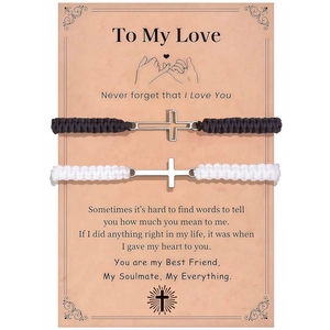 Detail of couple woven bracelets with stainless steel cross on a vintage gift card