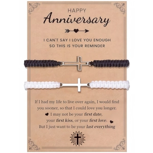 Detail of woven couple bracelets with silver cross charms on a vintage gift card