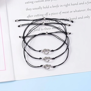 Three-piece adjustable friendship knot bracelets displayed on an open book background