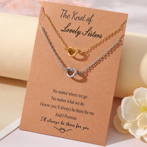 Detail of silver and gold knot necklaces on a sisters message gift card display