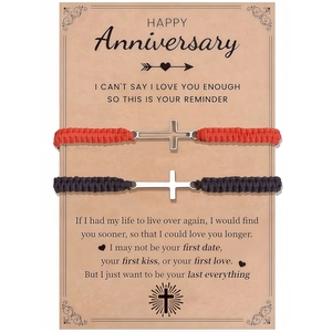 Close-up of cross charm woven couple bracelets on a vintage sentiment gift card
